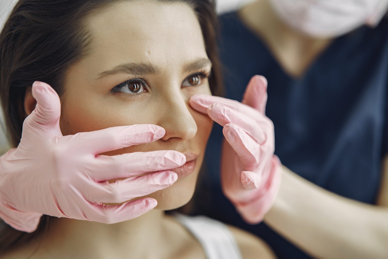 Cosmetologist holds hands near client's face. Woman with cosmetologist. Lady in a beauty studio.
